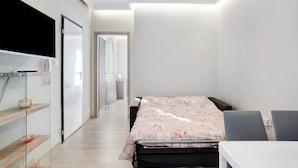 Une chambre à coucher comprenant un lit, des tables de chevet, une armoire et un miroir.