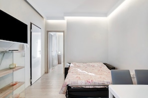 Een slaapkamer met een bed, nachtkastjes, een kledingkast en een spiegel.