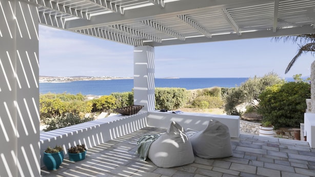 A covered outdoor seating area with a view of the sea. - Stunning Beachfront 3BR Villa (Paros)