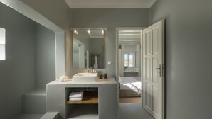 A modern bathroom with a large mirror, two sinks, and a bathtub. - Stunning Beachfront 3BR Villa (Paros)