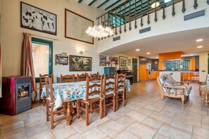 A spacious dining area with a fireplace, wooden chairs, and a table set for six. - Vacation Home "Mas Lucena" with Private Pool, Private Terrace & Wi-Fi (Alforja)