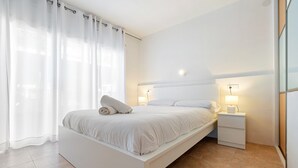 Un dormitorio moderno con cama, mesitas de noche y una mesilla.