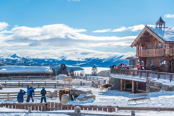 A wooden lodge with a balcony overlooking a snowy landscape and mountains. - Langedrag Naturpark (Nore og Uvdal)