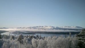 Eine Berglandschaft mit schneebedeckten Gipfeln und einem See im Vordergrund.
