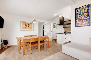 Un espacio habitable moderno con comedor, kitchenette y sofá.