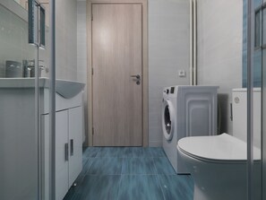 A compact bathroom with a washing machine, toilet, and a sink. - Comf Ap Next2 Museum&park (Athens)