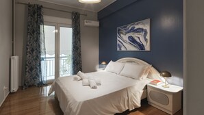 Une chambre à coucher avec un lit, une table de chevet, une lampe, un radiateur et une fenêtre avec des rideaux.