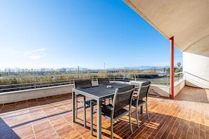 A terrace with a table and chairs, a view of a bridge, and a railing. - Villa 'De L'ebre' with Private Pool, Wi-Fi and Air Conditioning (Deltebre)