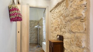 A narrow hallway with a stone wall, a wooden cabinet, and a tiled floor. - Apartment "Casa Virginia - Corbezzolo" with Shared Pool & Wi-Fi (Orco Feglino)