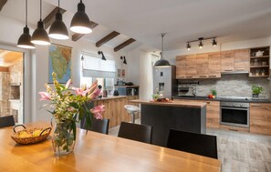 Enjoy cooking in this well-equipped kitchen with a central island, sink, stainless steel oven, and range hood.