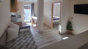 A modern apartment with a living room, dining area, kitchenette, and a small balcony. - Apartment 'Appartamento Zefiro' with Mountain View, Balcony and Wi-Fi (Livigno)