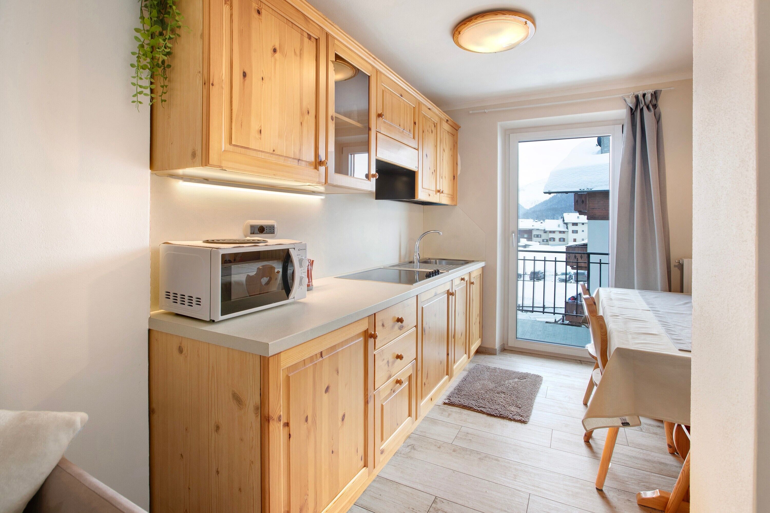 A modern kitchen with wooden cabinets, a microwave, and a sink.