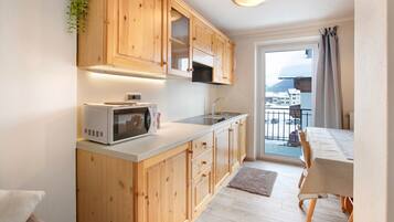 A modern kitchen with wooden cabinets, a microwave, and a sink.