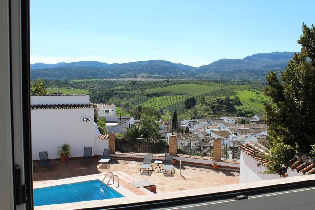 Una piscina en la azotea con vistas a un pueblo y montañas.