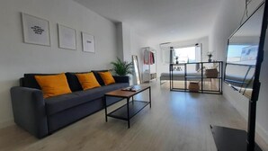A modern living room with a sofa, coffee table, and artwork on the wall. - Apartamentos Avanel (Ronda)