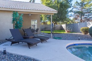 A covered patio area with lounge chairs and a swimming pool. - Cozy House w/ Pool, Near State Farm Stadium (Glendale)