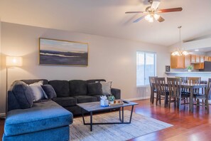 A living room with a sofa, coffee table, and a painting on the wall. - Cozy House w/ Pool, Near State Farm Stadium (Glendale)