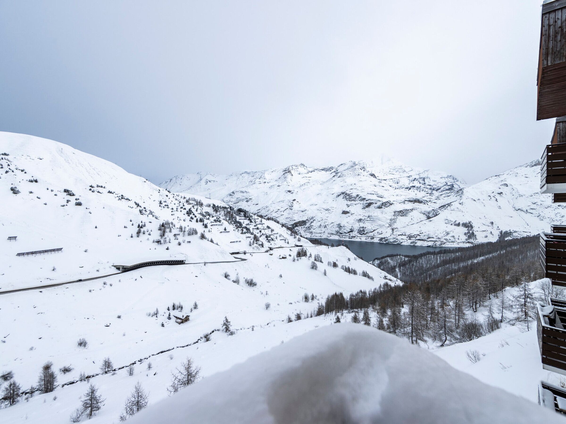 A snow-covered mountain landscape with a wooden building in the foreground.