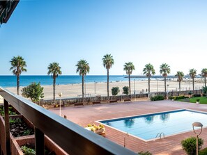 Ein Poolbereich mit Blick auf Strand und Meer.
