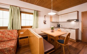 A compact kitchen with a dining area, a bench, and a small table.