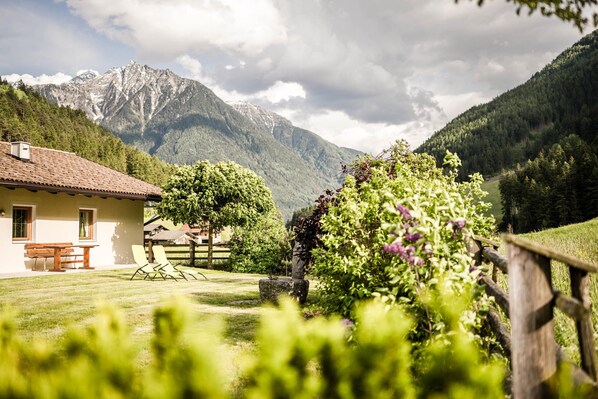A house with a patio, a wooden fence, and a mountain backdrop.