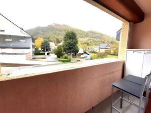 En balkong med utsikt över ett bostadsområde, ett berg och en whiteboard.