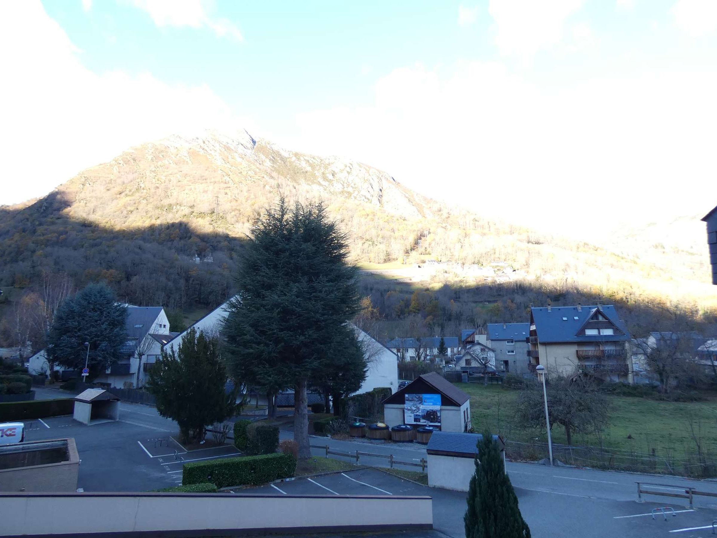 A view of a parking lot with a mountain in the background.