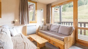 A cozy cabin interior with a wooden bench, a sofa, and a small table.