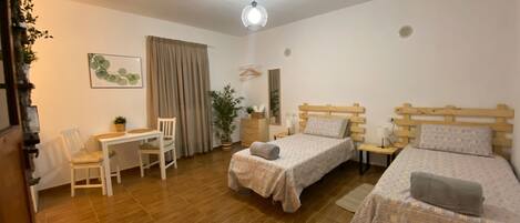Ein Schlafzimmer mit zwei Betten, einem Schreibtisch und einem Stuhl.
