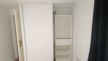 A room with a white wardrobe, a door, and a radiator.