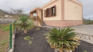 A modern building with a flat roof, a covered porch, and a staircase leading to the entrance. - Holiday Home 'Casa Girdana' with Sea View, Private Terrace and Wi-Fi (Valverde)