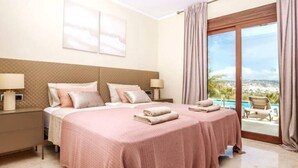 Ein Hotelzimmer mit zwei Betten, einem großen Fenster und Blick auf einen Pool, der durch das Fenster zu sehen ist.