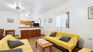 A living room with a sofa, a coffee table, and a kitchen area in the background.