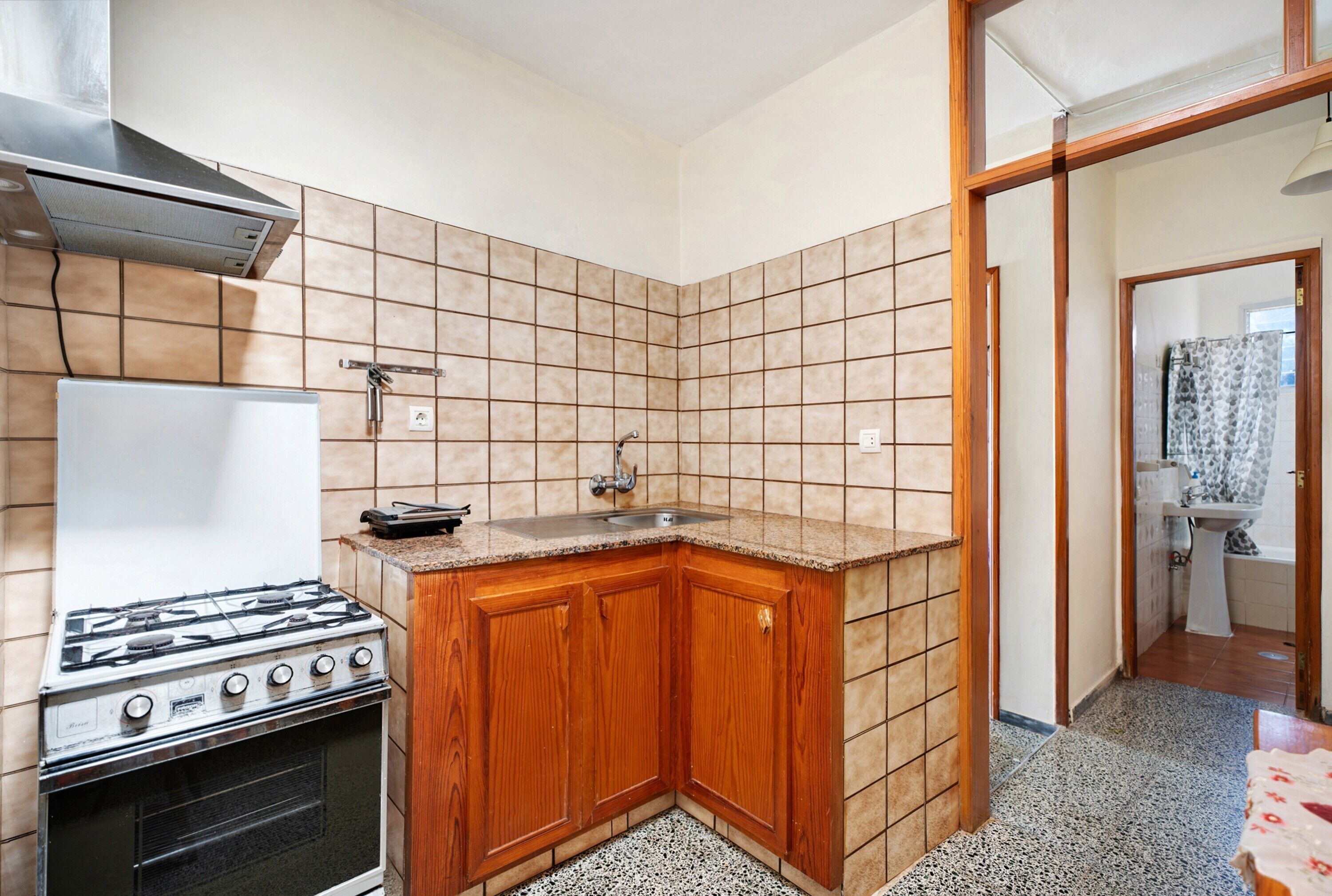 Una cocina con estufa, pileta y armarios de madera.