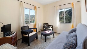 Une pièce comprenant un canapé, deux fauteuils, un téléviseur et une table.