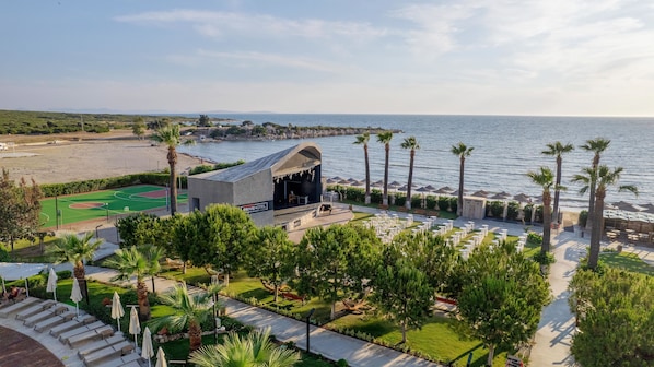 A beachfront property with a stage, outdoor seating, and a tennis court. - Agaya Didim Resort Hotel -Ultra All Inclusive (Didim)
