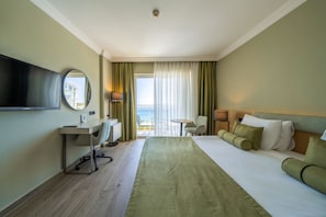 A hotel room with a bed, desk, chair, TV, and a view of the outdoors. - Agaya Didim Resort Hotel -Ultra All Inclusive (Didim)
