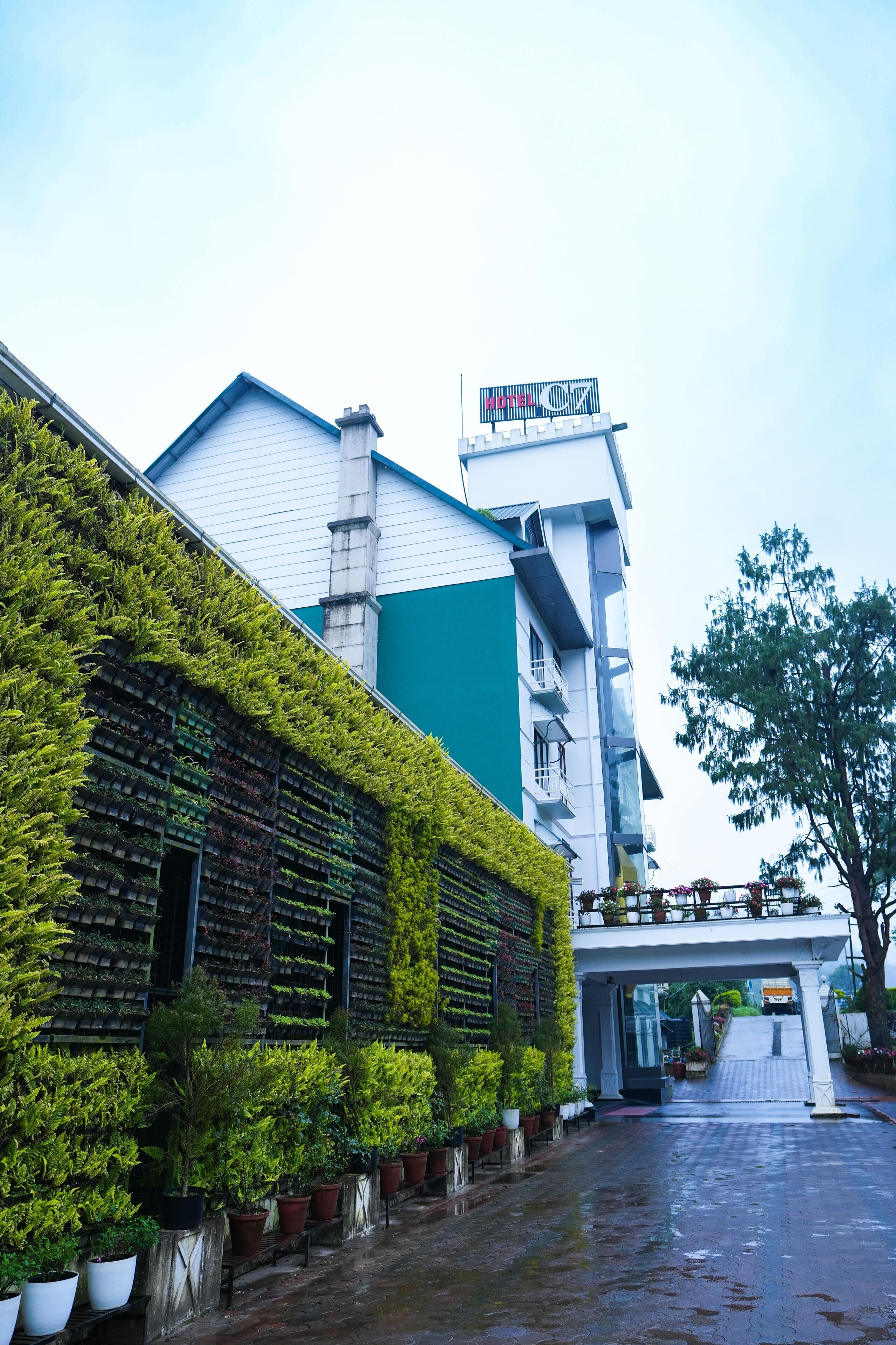 A hotel with a green facade, a sign reading "HOTEL 07", and a wet ground.
