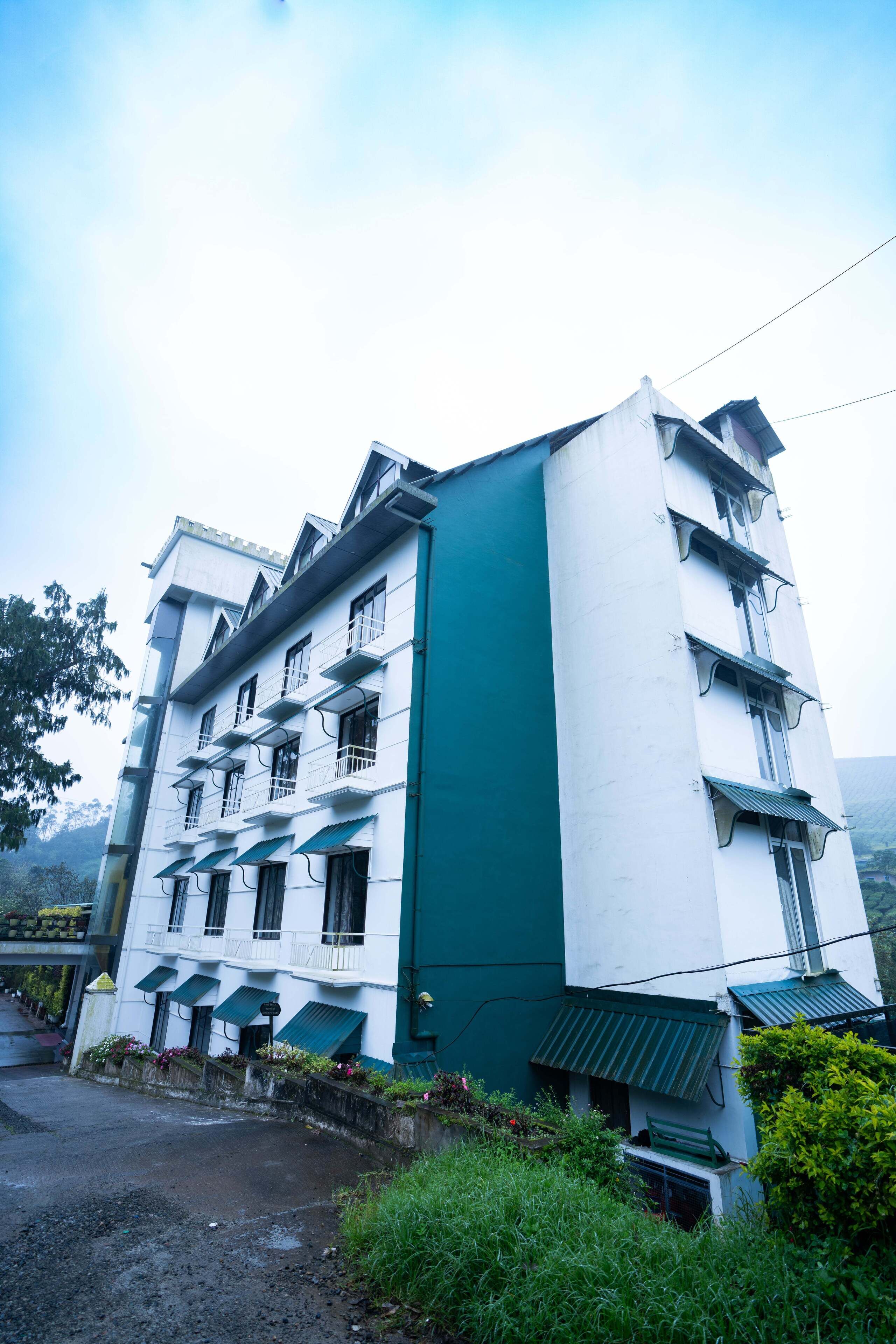 A multi-story building with balconies, a green awning, and a staircase leading to the entrance.