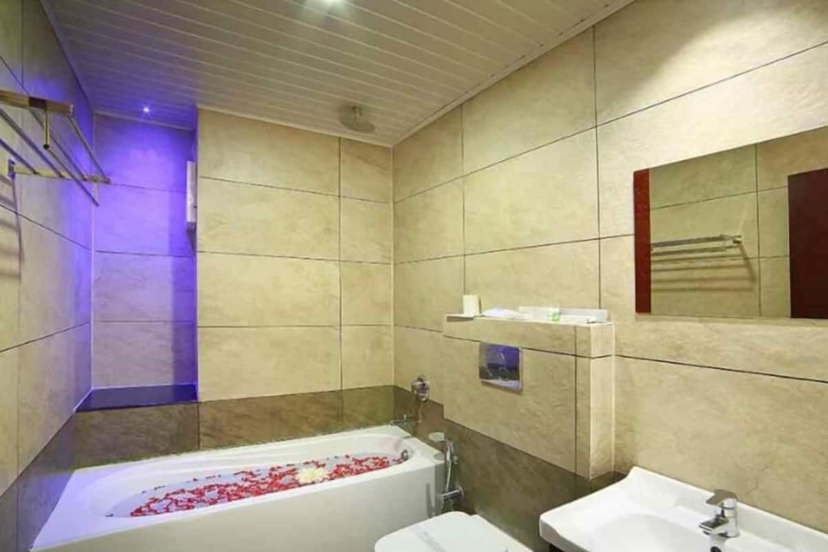A modern bathroom with a bathtub, a sink, and a mirror.