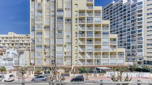 A multi-story residential building with balconies, a parking area, and a clear sky. - Apartment 'Les Embruns' with Sea View, Private Terrace and Balcony (Empuriabrava)