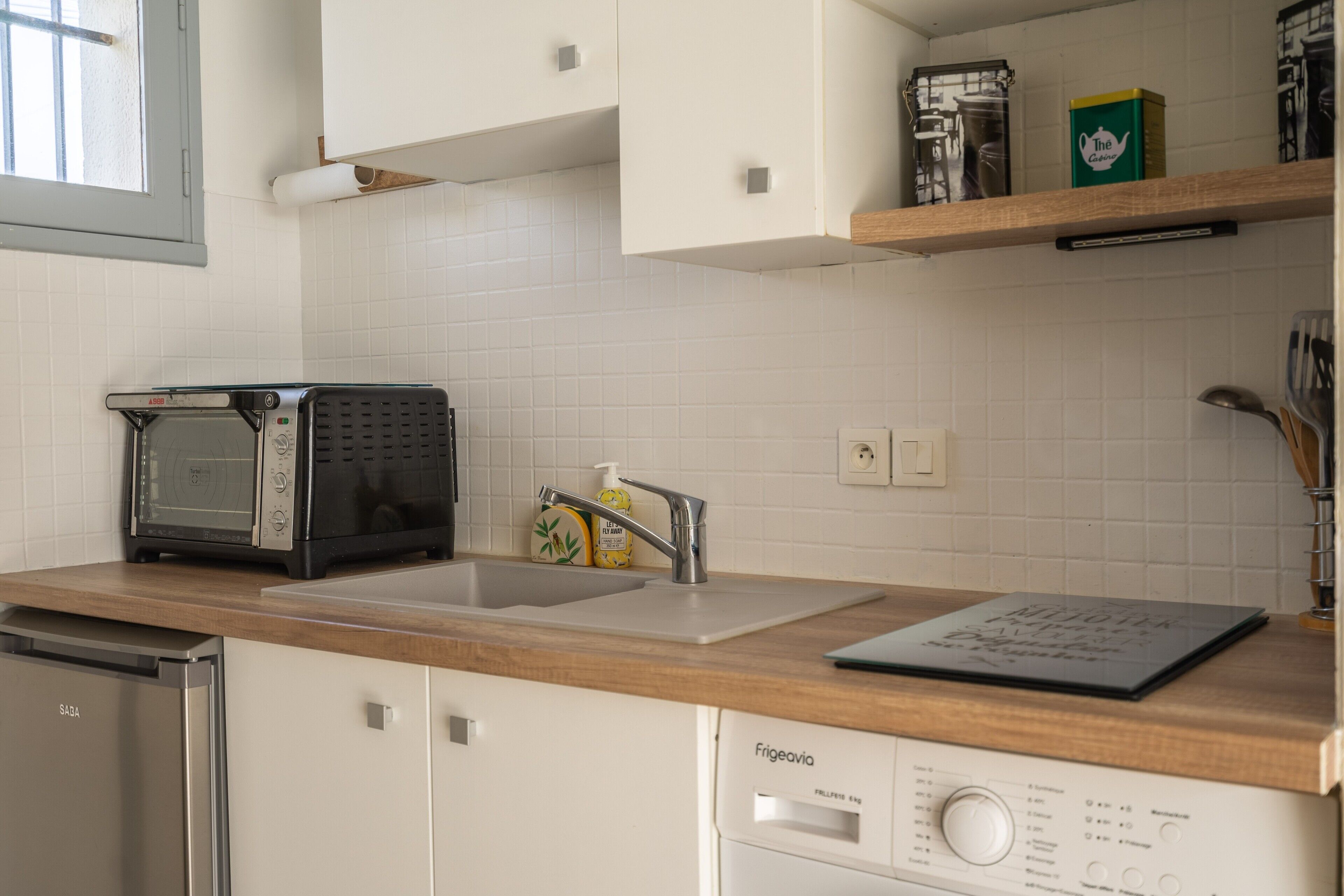 Et køkken med en toaster, vask, opvaskemaskine og et Frigidaire-køleskab.