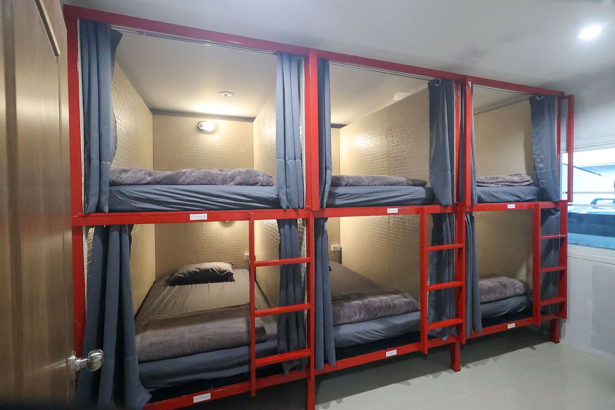 Habitación con literas, cuatro en total, cada una con cortina.