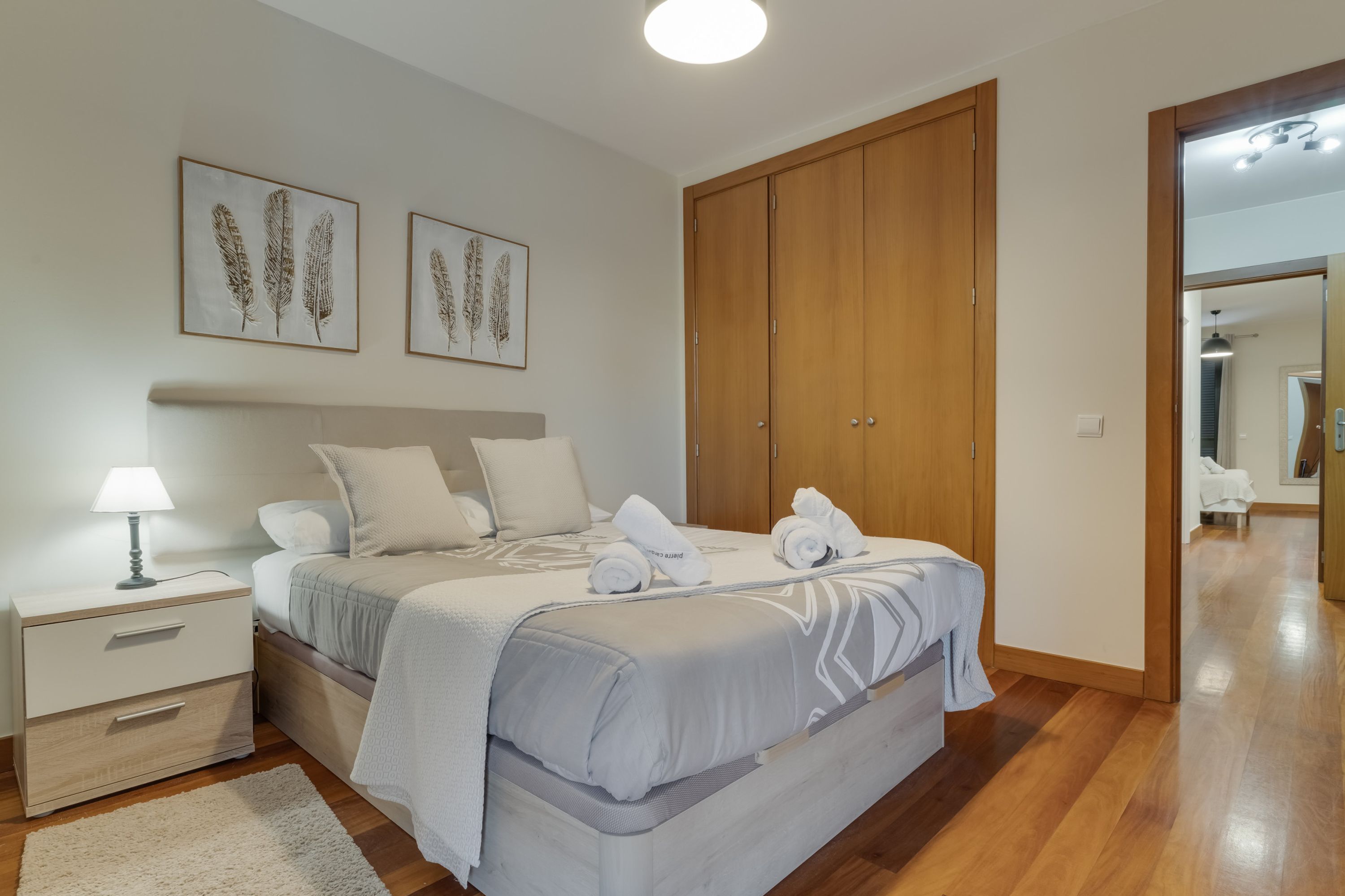 Une chambre à coucher avec un lit, une table de chevet et une armoire en bois.