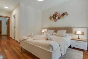 A neatly arranged bedroom with a bed, bedside tables, and a wall decoration. - Lido Charm by Atlantic Holiday (Funchal)