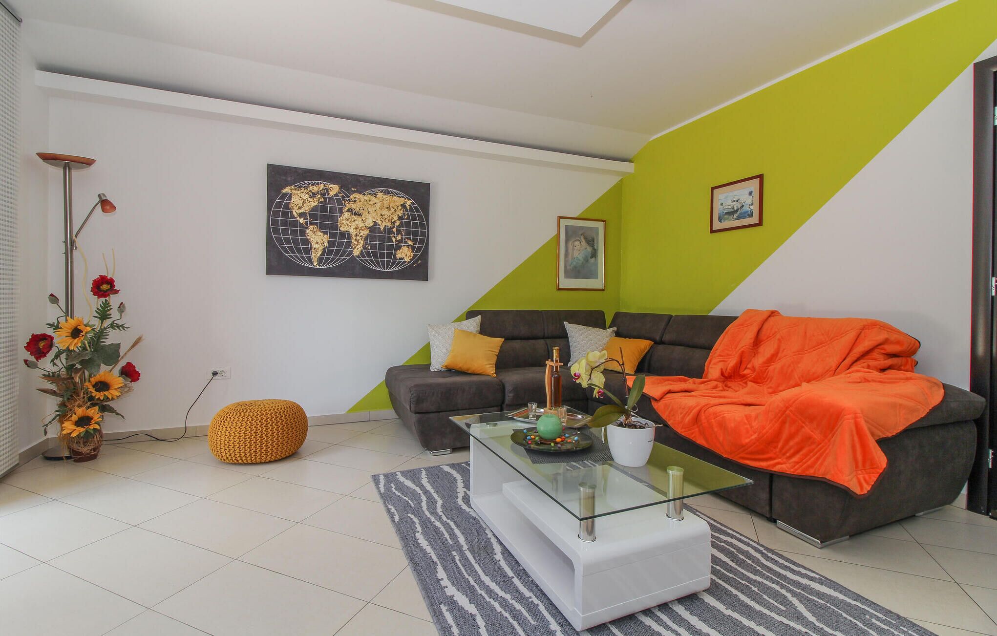 A modern living room with a sofa, a glass coffee table, and a decorative vase.