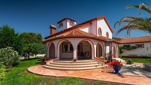 A two-story house with a tiled roof, a central patio with steps, and a garden with various plants and flowers. - Stunning home in Kukci - Nova Vas (Kukci - Nova Vas)