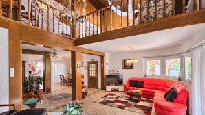 A spacious living room with a red sofa, a television, and a dining area in the background. - Stunning home in Kukci - Nova Vas (Kukci - Nova Vas)