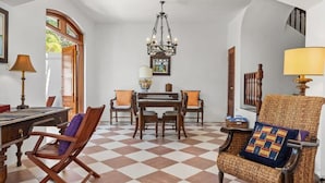 Comedor con piso de tablones, mobiliario de madera y una araña.