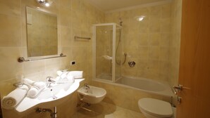 Ein Badezimmer mit Waschbecken, Spiegel, Toilette und Dusche.